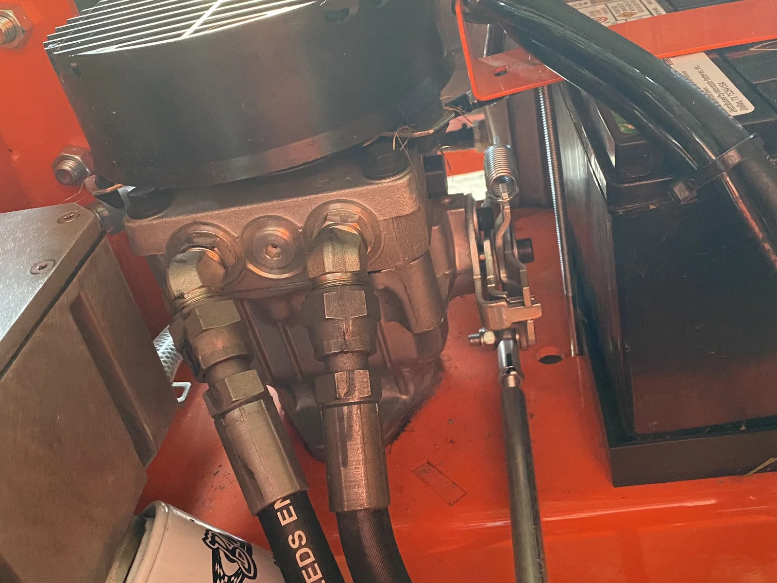 Hydro-Gear pump close-up with hydraulic hoses — what the lap-bar linkage ultimately drives